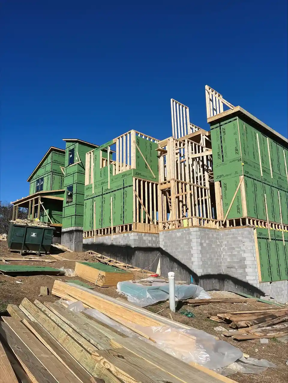 One Salesman, One Bill: multi-story framed home on a block foundation with lumber staged in the foreground
